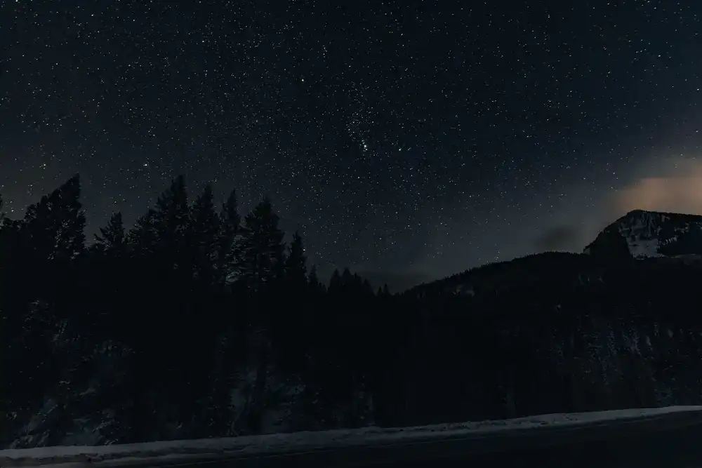 A brilliant night sky filled with stars over a dark landscape