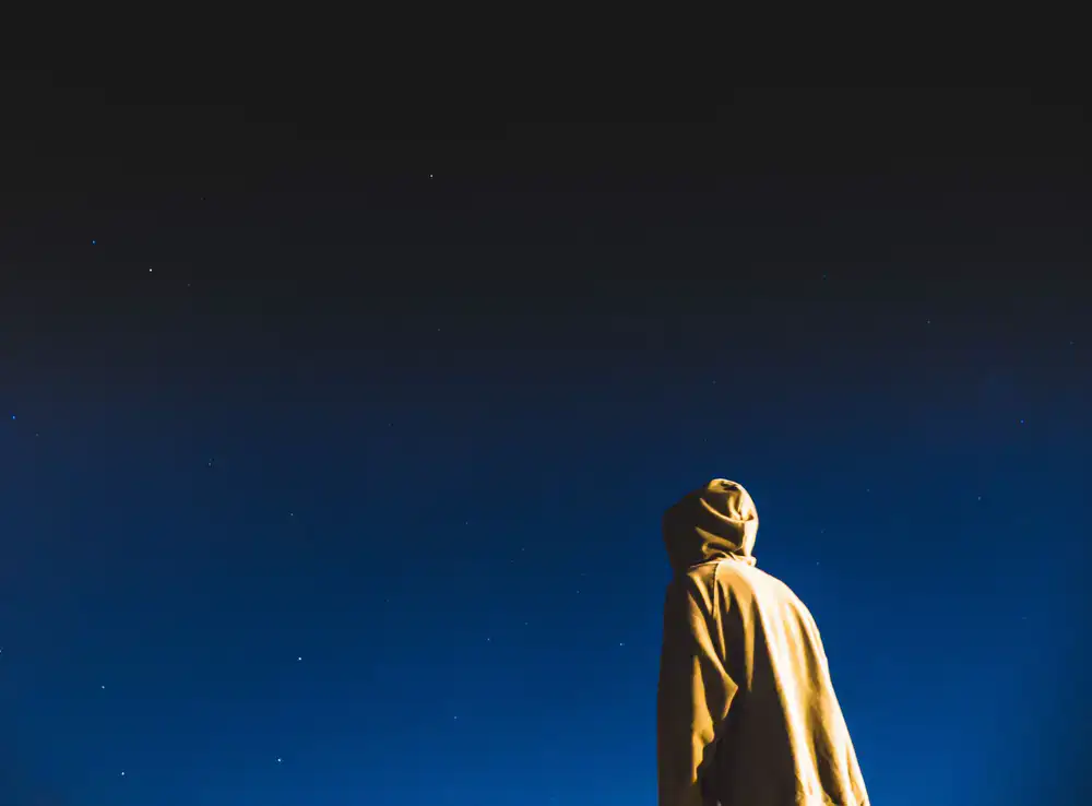 Observer standing under the stars wearing a heavy coat