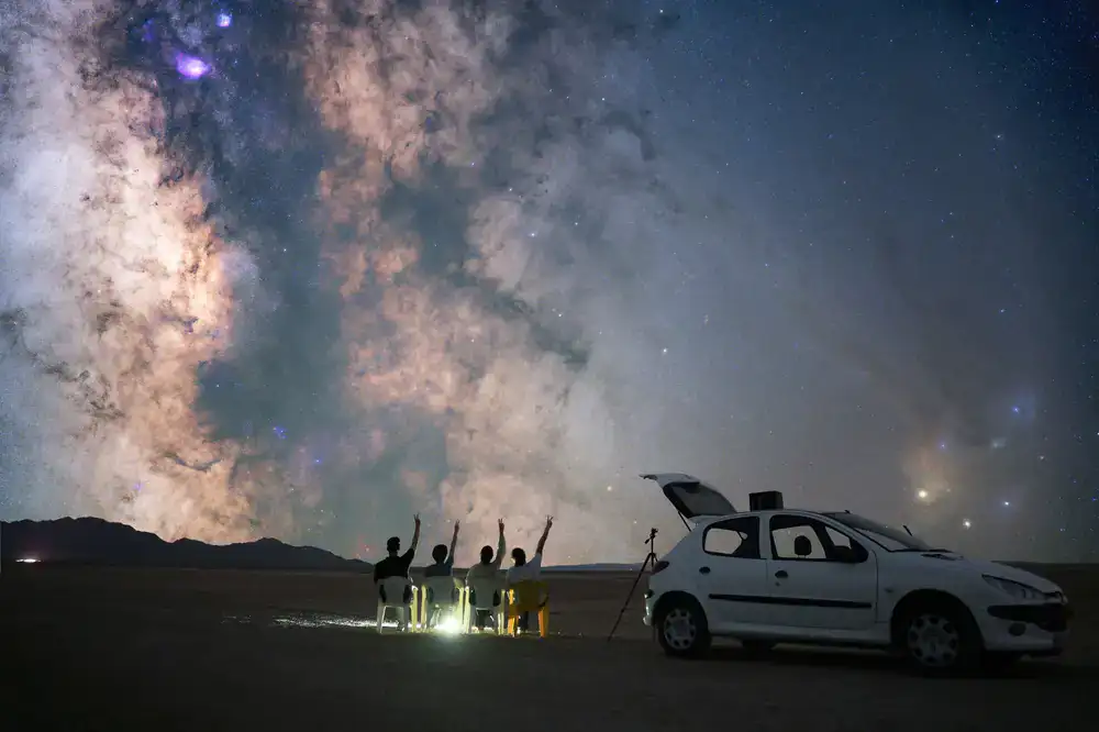 A group of people looking through telescopes at the night sky
